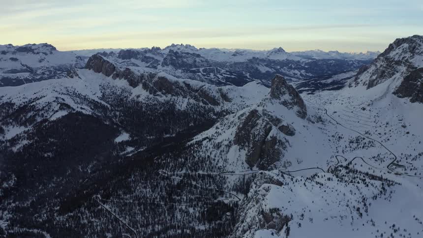 A mountain range covered in snow and ice with the sky and clouds in the background
