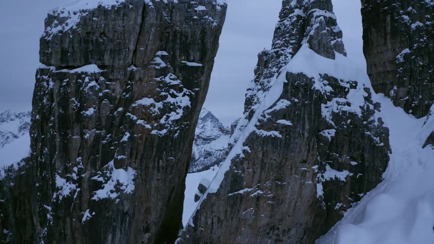 A flat rock formation and a mountain peak sit close together and form a v shaped entrance