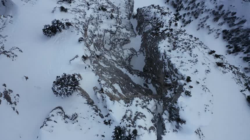 A creek runs between a crack in a mountain