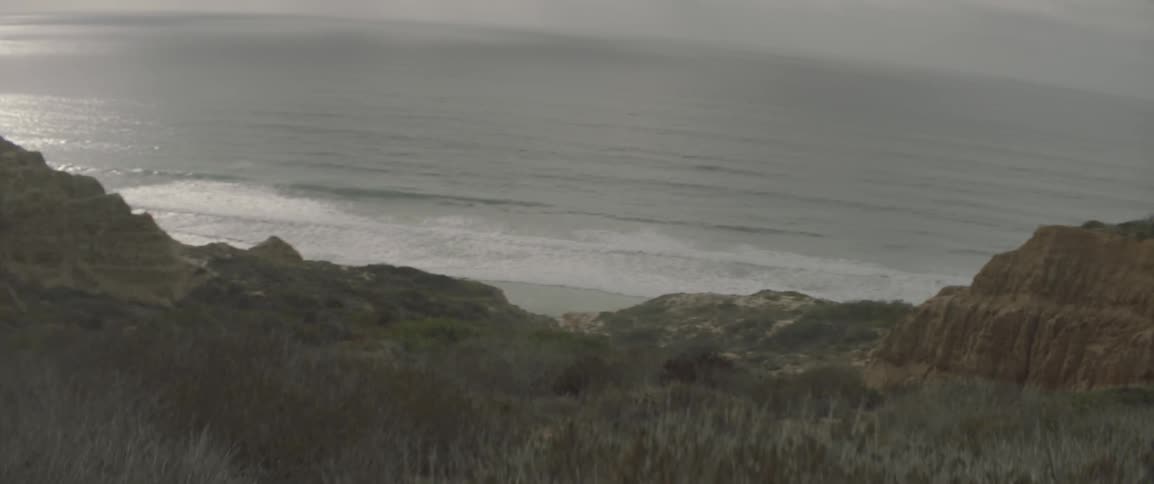 Waves roll onto the shore on a cloudy day