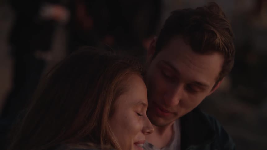 Couple snuggling and talking outdoors