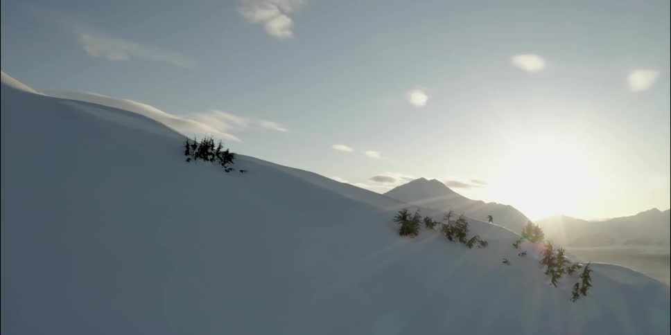 Person moves up snow covered mountain slope as sun shines rays across sky from above mountains in distance
