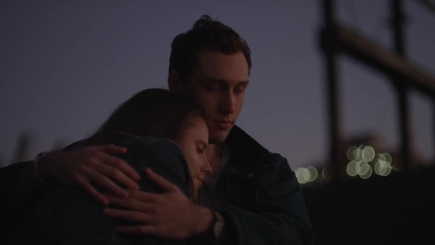 A man is holding a woman at sunset