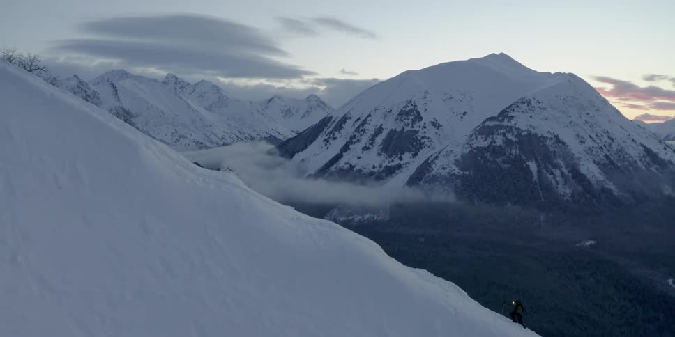 A person is hiking up the snow covered mountain