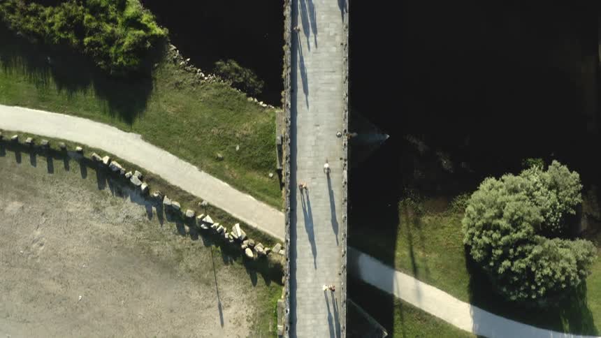 Aerial view of vehicles parked near a pedestrian overpass on a park