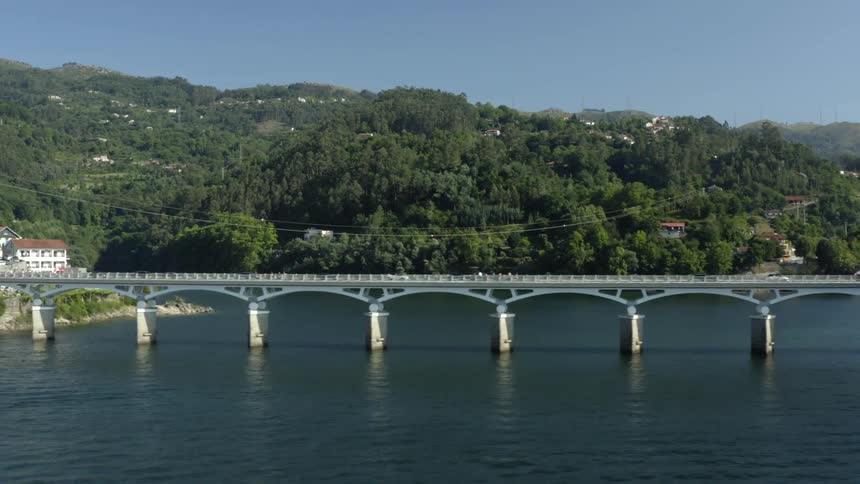 Cars drive over the bridge crossing the river