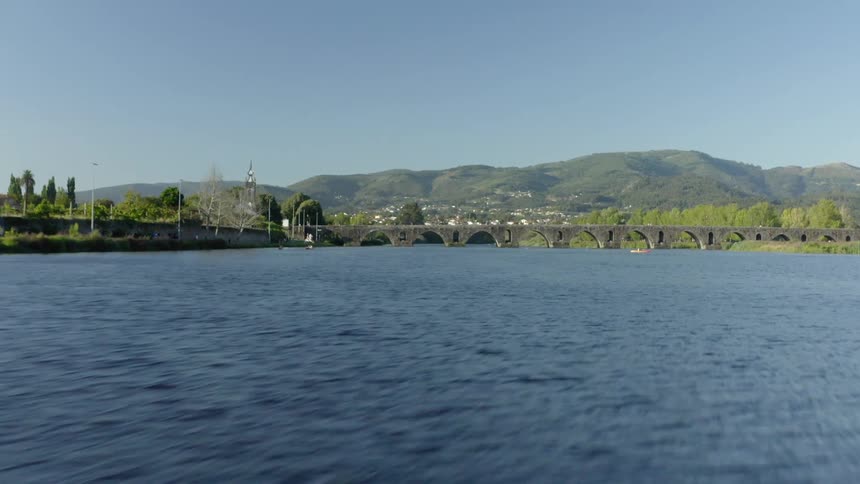 An aerial view flying over a river with people on it