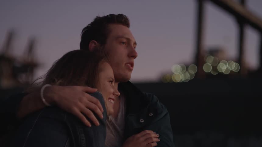 A man and woman snuggle near dusk