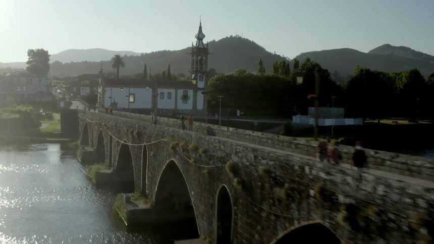 Stone bridge over a river near a small town at morning