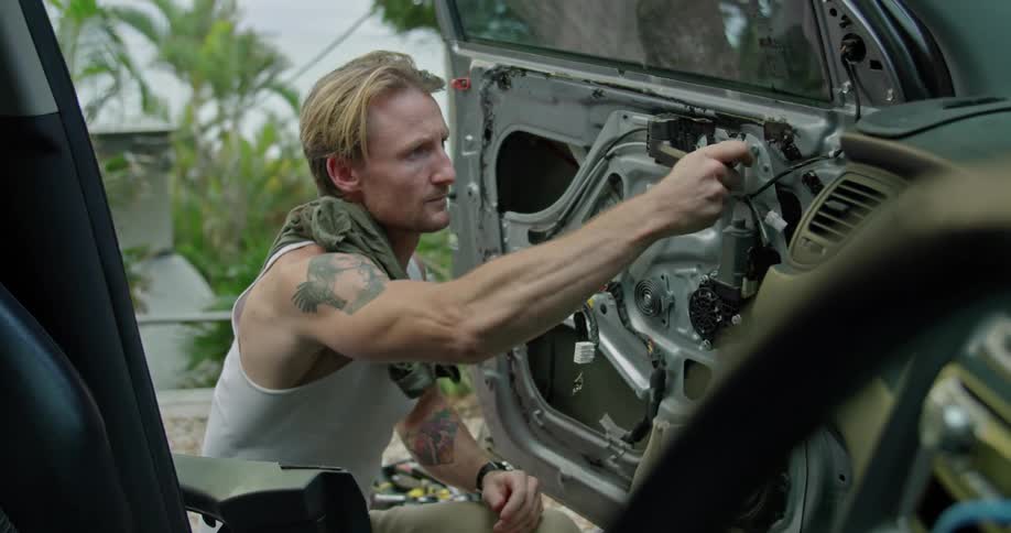 A man uses a torque wrench to repair a car door