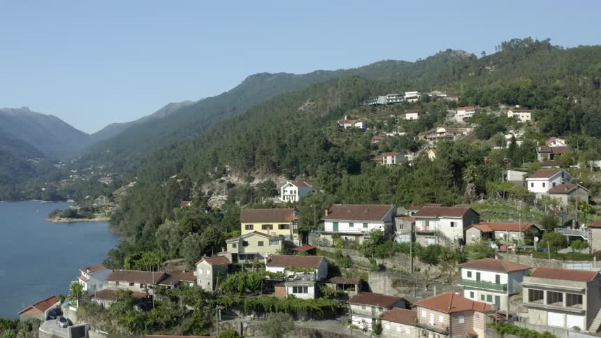 An aerial view of neighborhoods in a coastal town along a mountain ridge in the daytime
