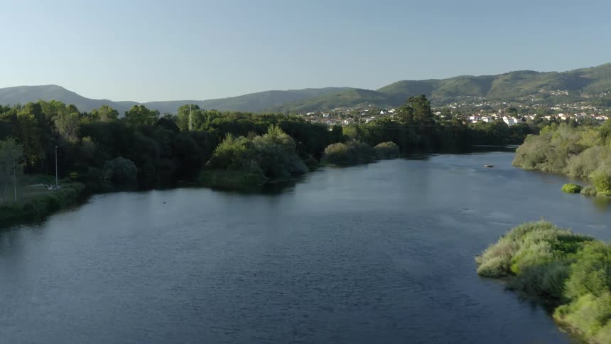 A river runs towards the town by the hills