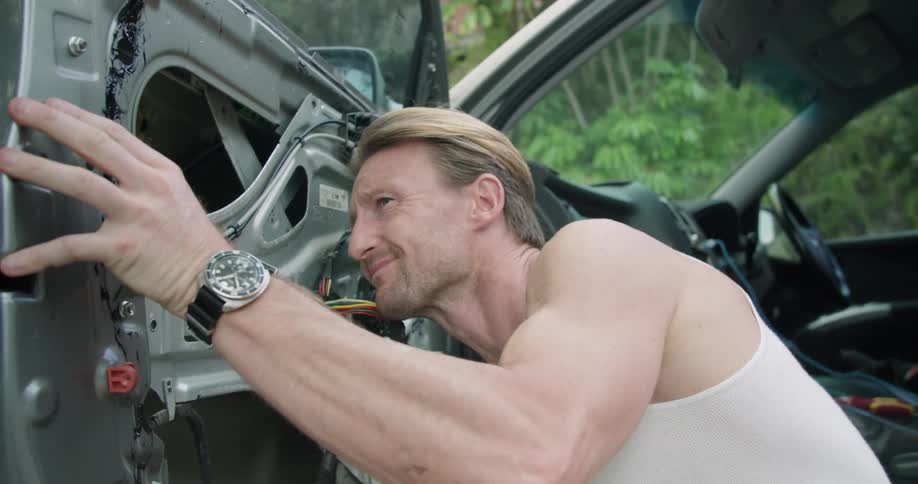 A man is taking apart a car door