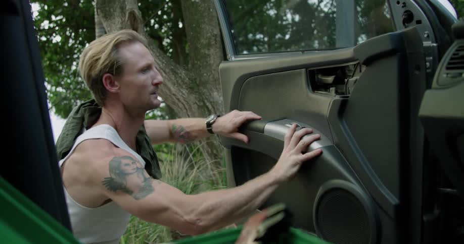 A man is taking apart the drivers side door of an automobile