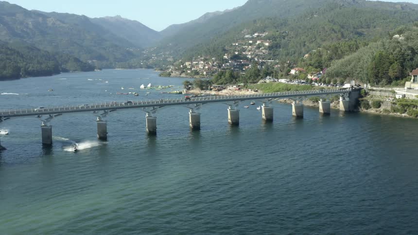 Boats and vehicles travel by the bridge