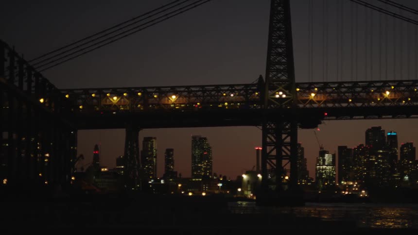 A bridge in front of a city at night