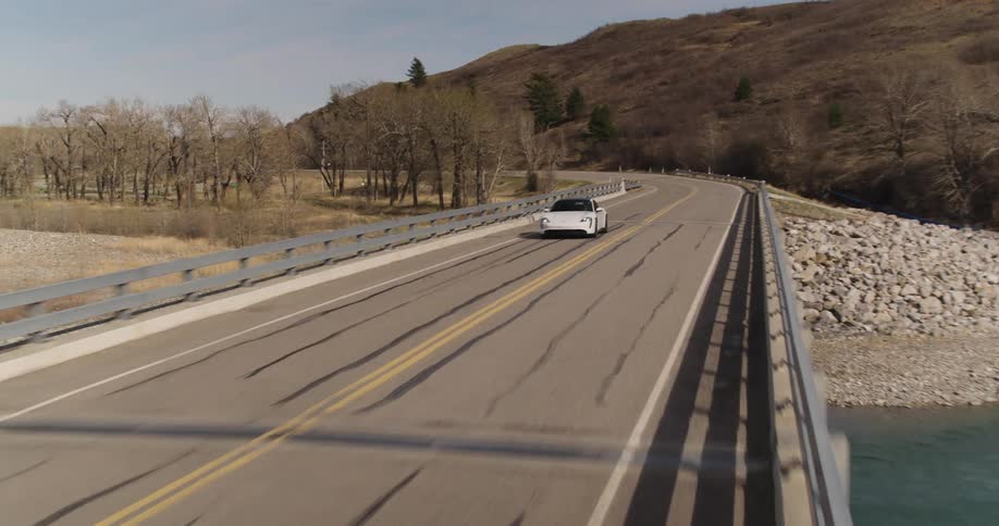 electric sports car car driving over bridge