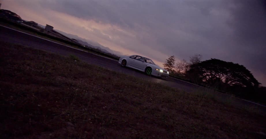 A sports car drifts and starts to slide sideways on a race track