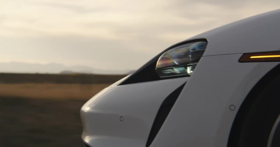 White electric sports car driving at sunset 1