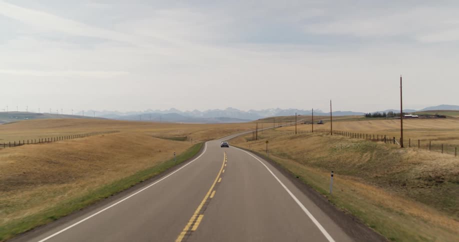 An electric sports car is traveling on a highway road in the country