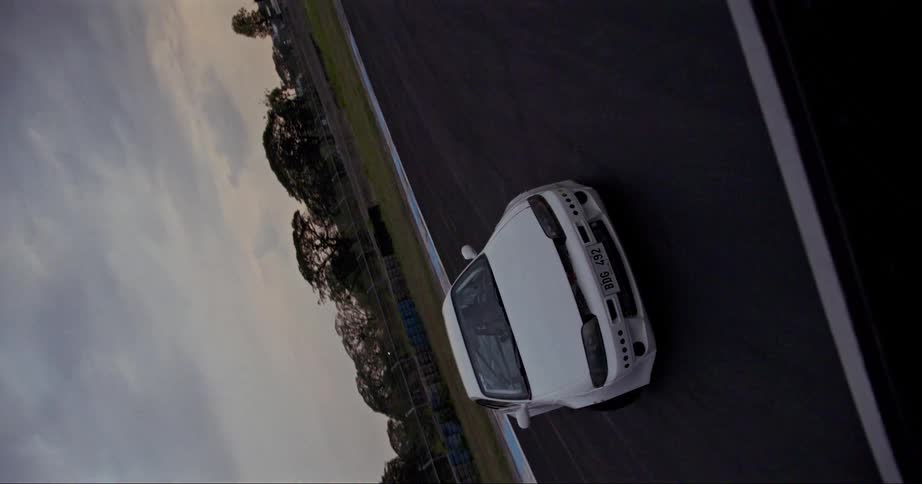 People driving in a white car on black top outdoors