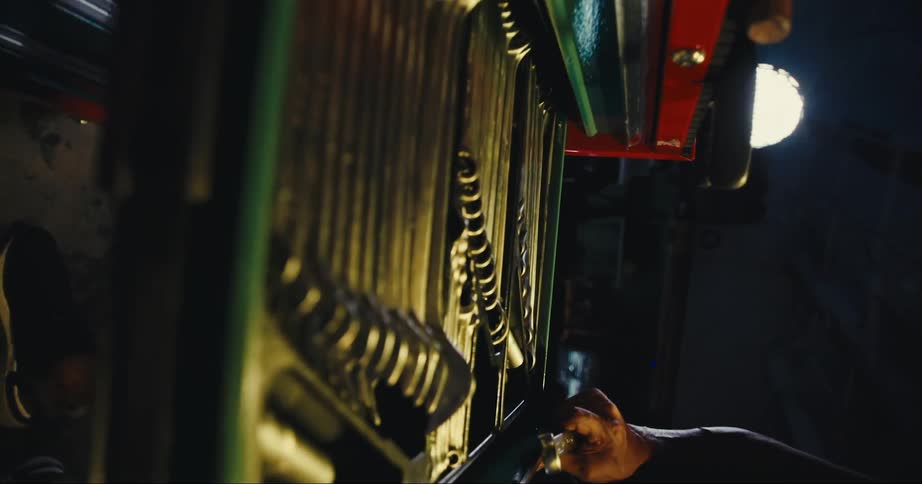 A man in a garage taking a tool from a toolbox with a wall in the background