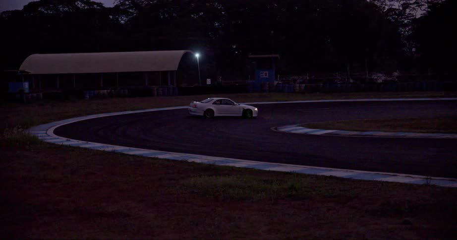 A sports car drifts while going around a curve on a track