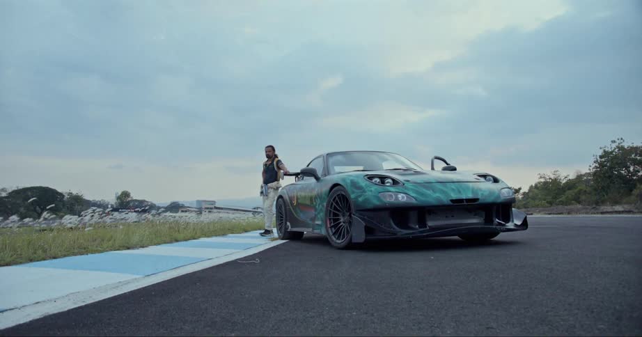 A man is standing outdoors by his vehicle