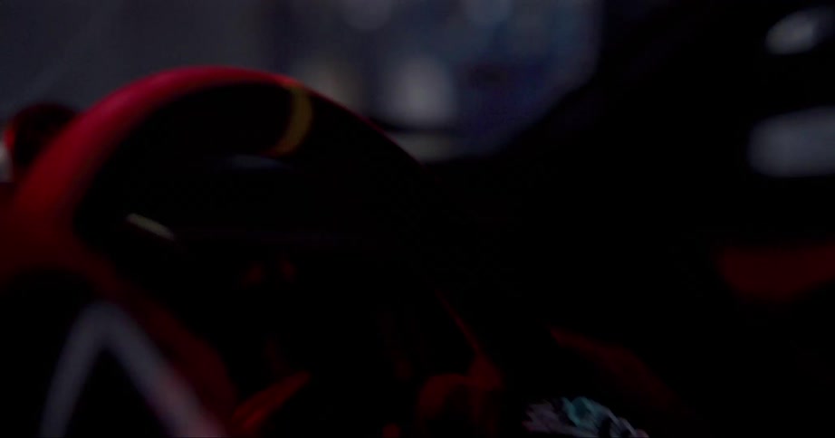 A drivers gloved hands grip and turn a race car steering wheel