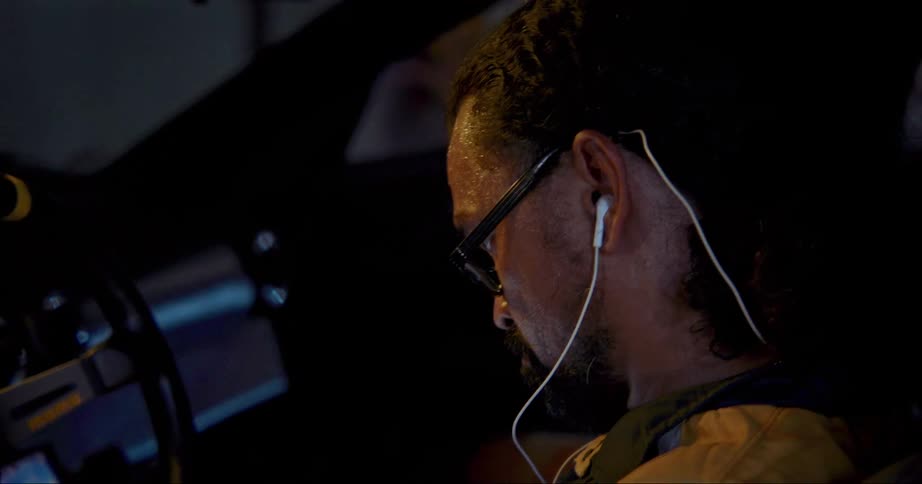 A man working on things on a laptop in a car