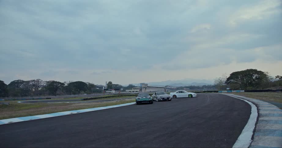 Sports cars parked on a race track near a car spinning