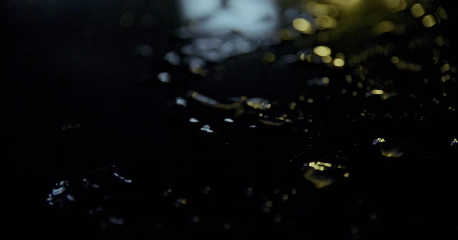 Water droplets fall on glass during the night