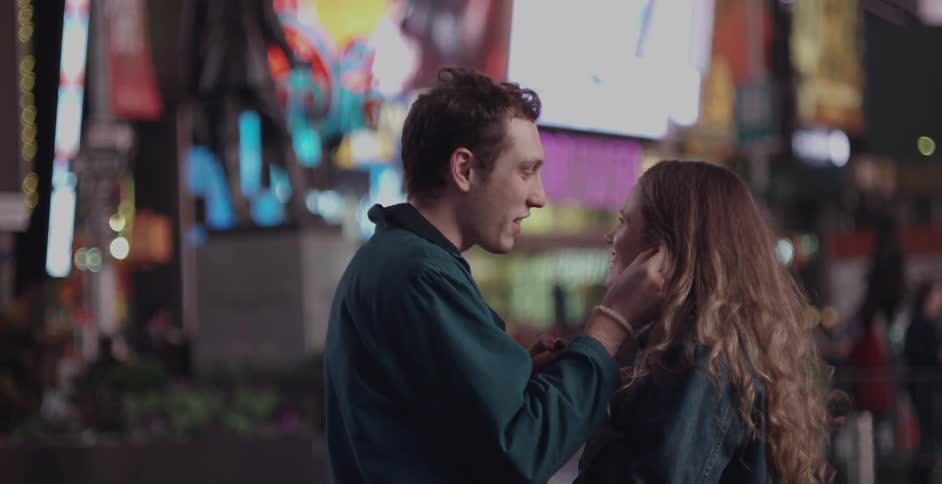 A man puts headphones in a woman's ears