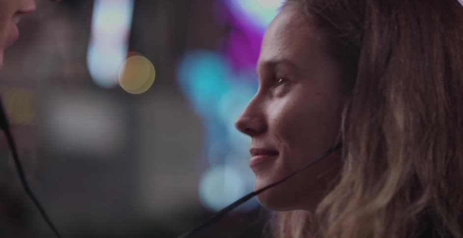 A woman and man share a set of earphones