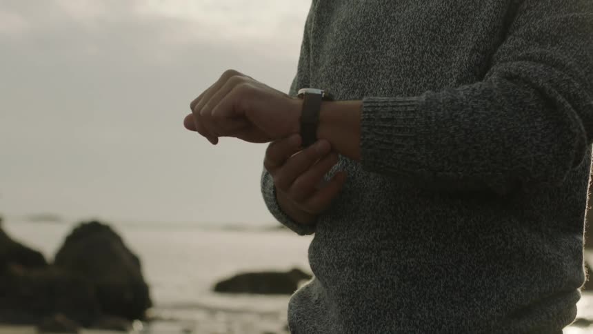 A man looking at his watch outdoors