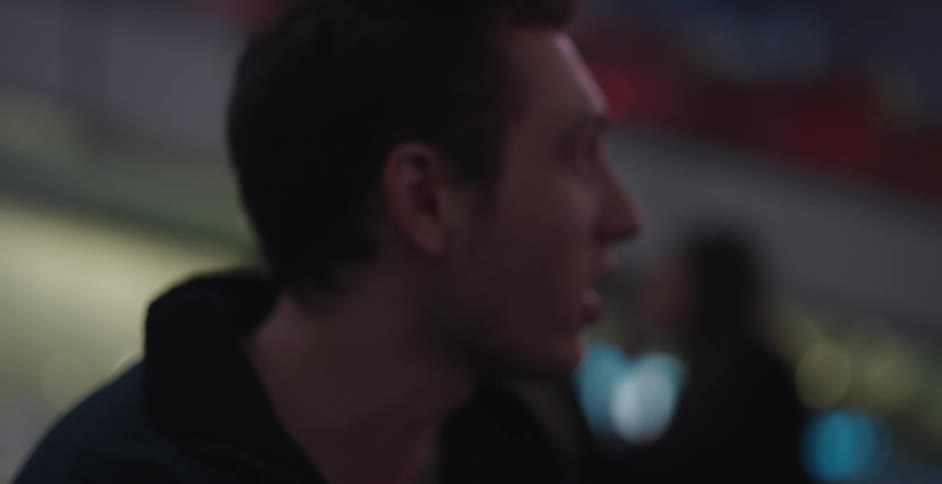 Man and woman talking while outdoors in the city at night