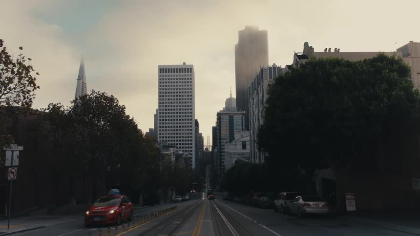 A red car drives on the city street