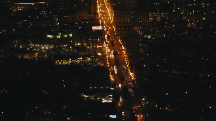 Aerial view of cars driving on a large avenue in the city at night