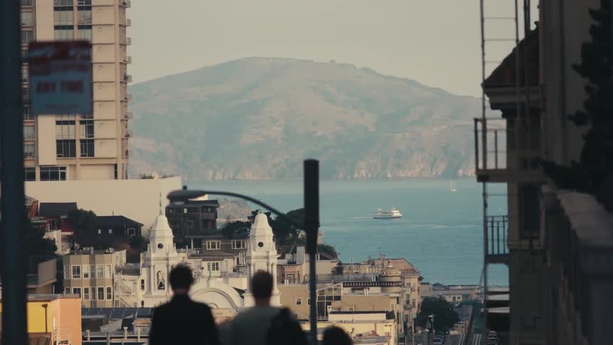 A small group of people walking in a downtown area on the water