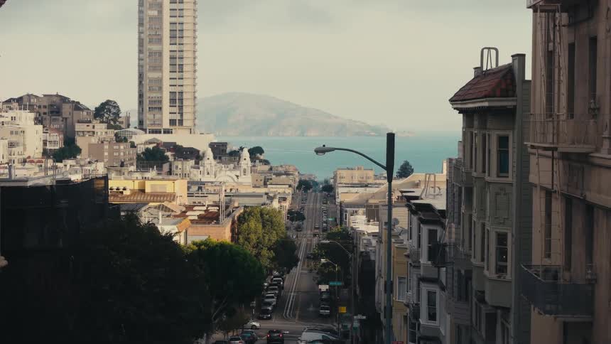 City street leading to coast with island and sea seen from city apartment