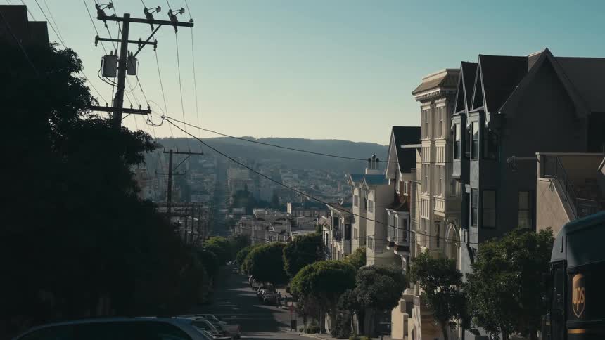 The downtown area of a town near mountains with cars and buildings lining the streets