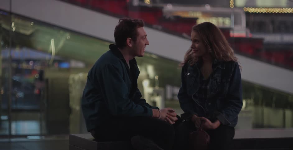 Couple sitting on an outdoor railing in the city