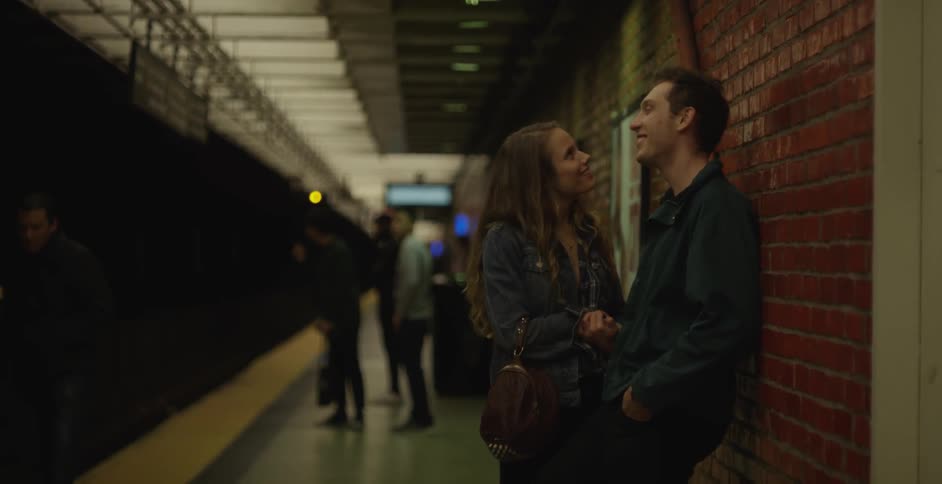 Man and woman talking in a train station at night