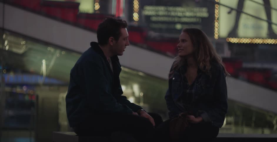 Couple sitting on an outdoor railing in the city