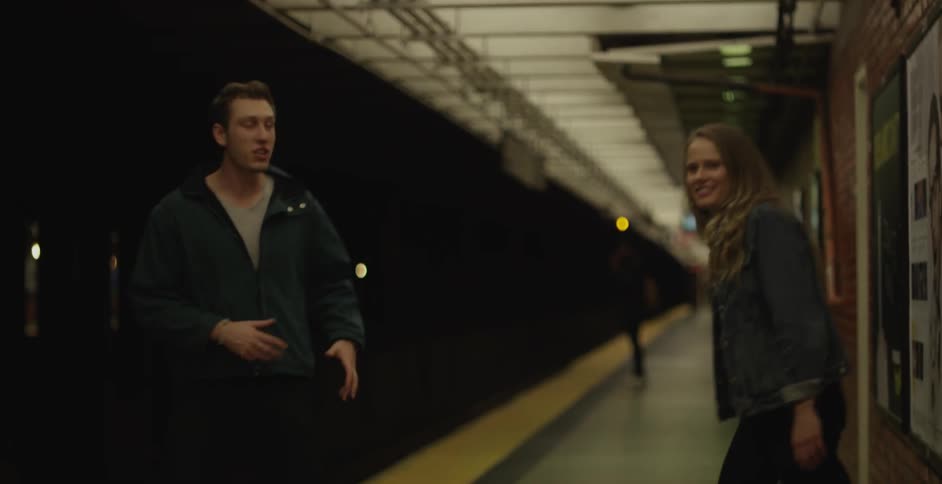 A man and women talk on a train platform