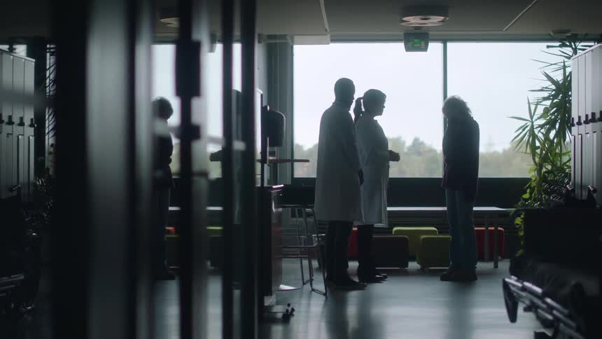 Doctors walk toward patients next of kin to give them bad news then comfort them as they cry