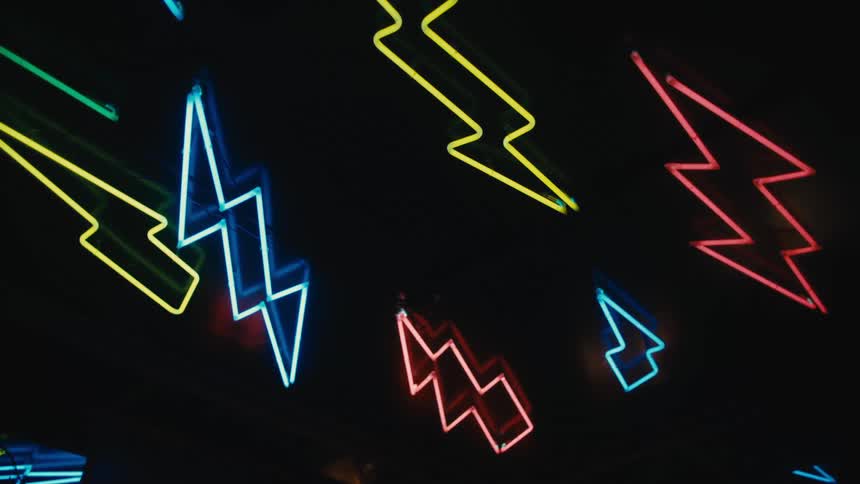 The wall is covered in neon lights in the shape of lightning bolts