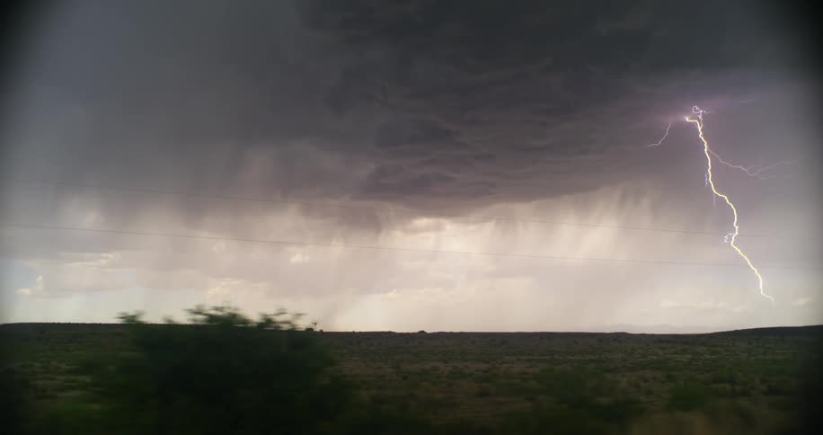 Lightning storm and rain over the fields at evening