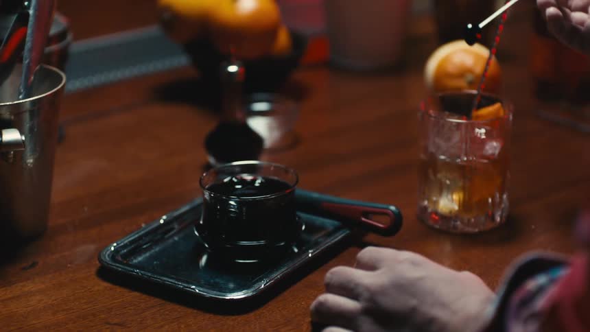 Man picks prepares a cocktail over a bar