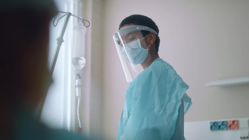 A doctor looks over to the patient